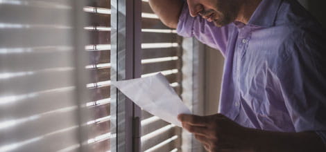 Man reading letter by window